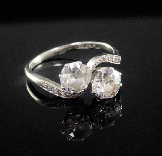 A mid 20th century 18ct white gold and platinum, two stone diamond crossover ring, size P.